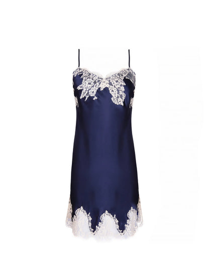 A navy satin slip dress with light lace trim is displayed against a white background.
