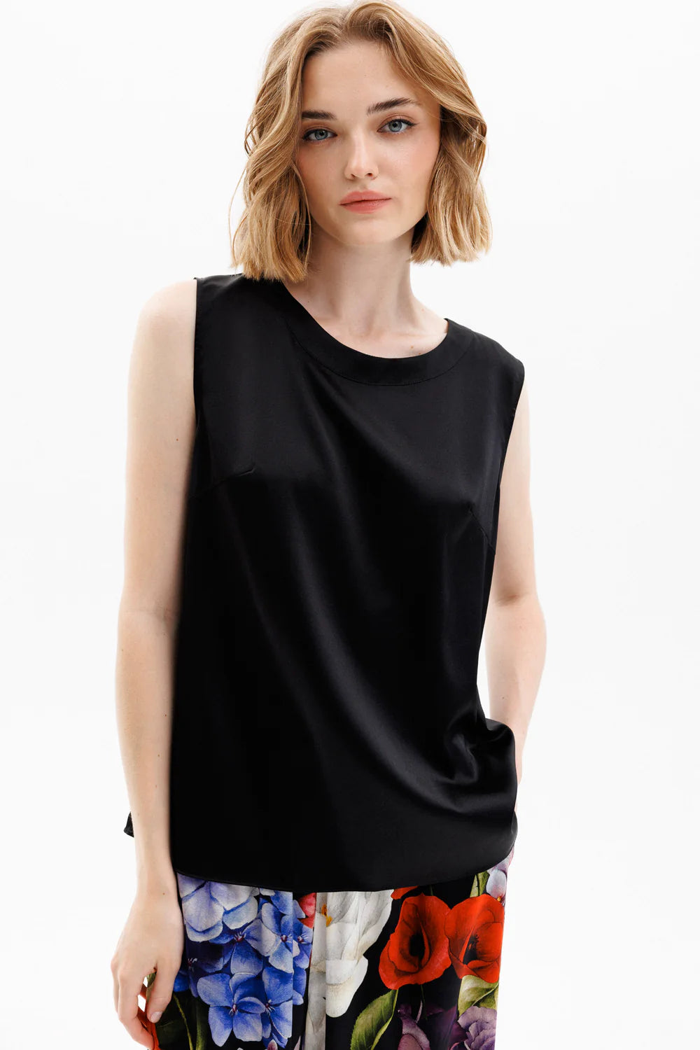 Woman wearing a black silk sleeveless top with a colorful silk floral pants (sold separately)