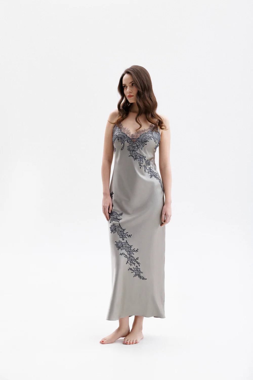 Woman wearing a silver silk sleeping  gown with floral embroidery showing the full figure picture