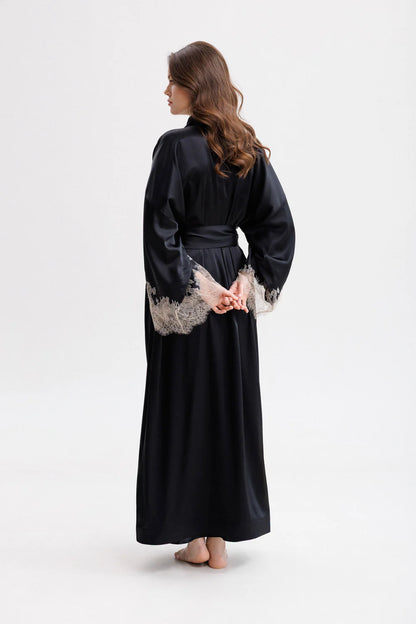 Woman wearing a long classy silk kimono stile dressing gown with floral Leavers Lace embroidery. Silk wide long belt giving the touch of the unique stile. Full back picture.