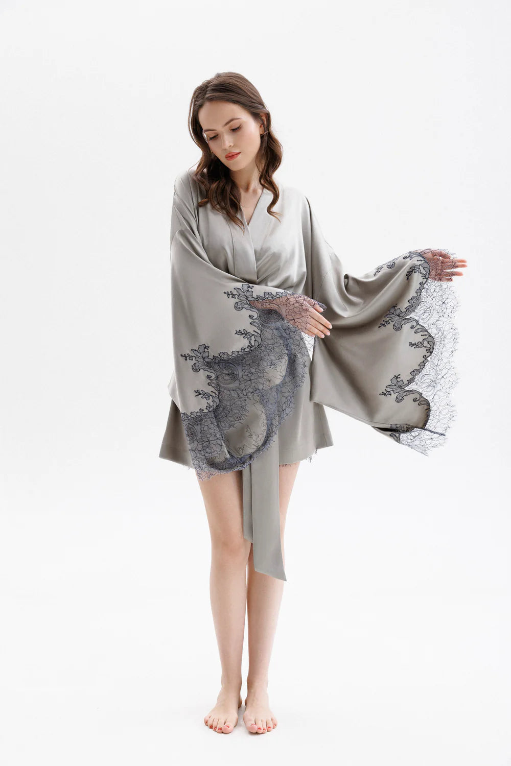 Woman wearing a gray silk robe with Leavers Lace sleeves showing the elegance of the sleaves