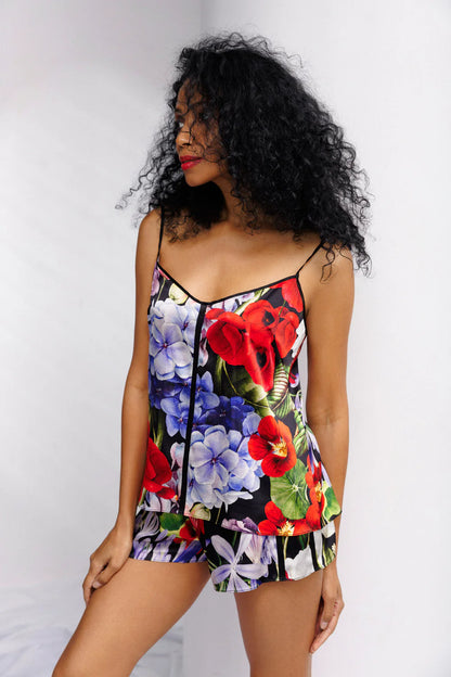 Woman wearing a colorful floral silk set of camisole and shorts. Showing the front full look.